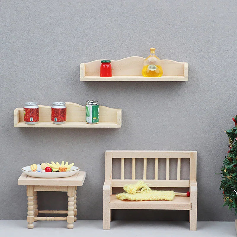 A display of miniature dollhouse furniture including two wooden shelves on a wall, a table with fruit, a bench, and a