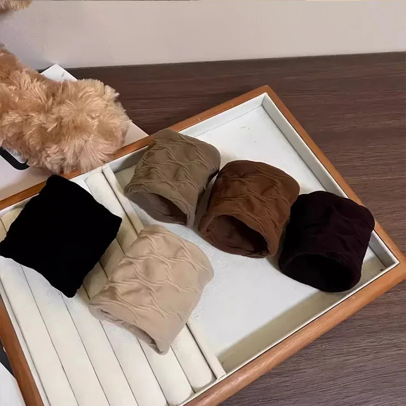 Four assorted color fabric hair scrunchies arranged on a display tray