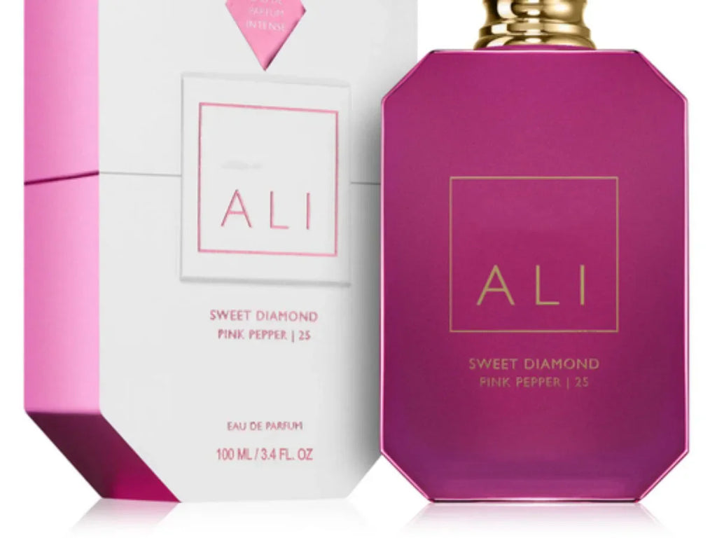 Close up of a pink perfume bottle and its matching octagonal packaging box