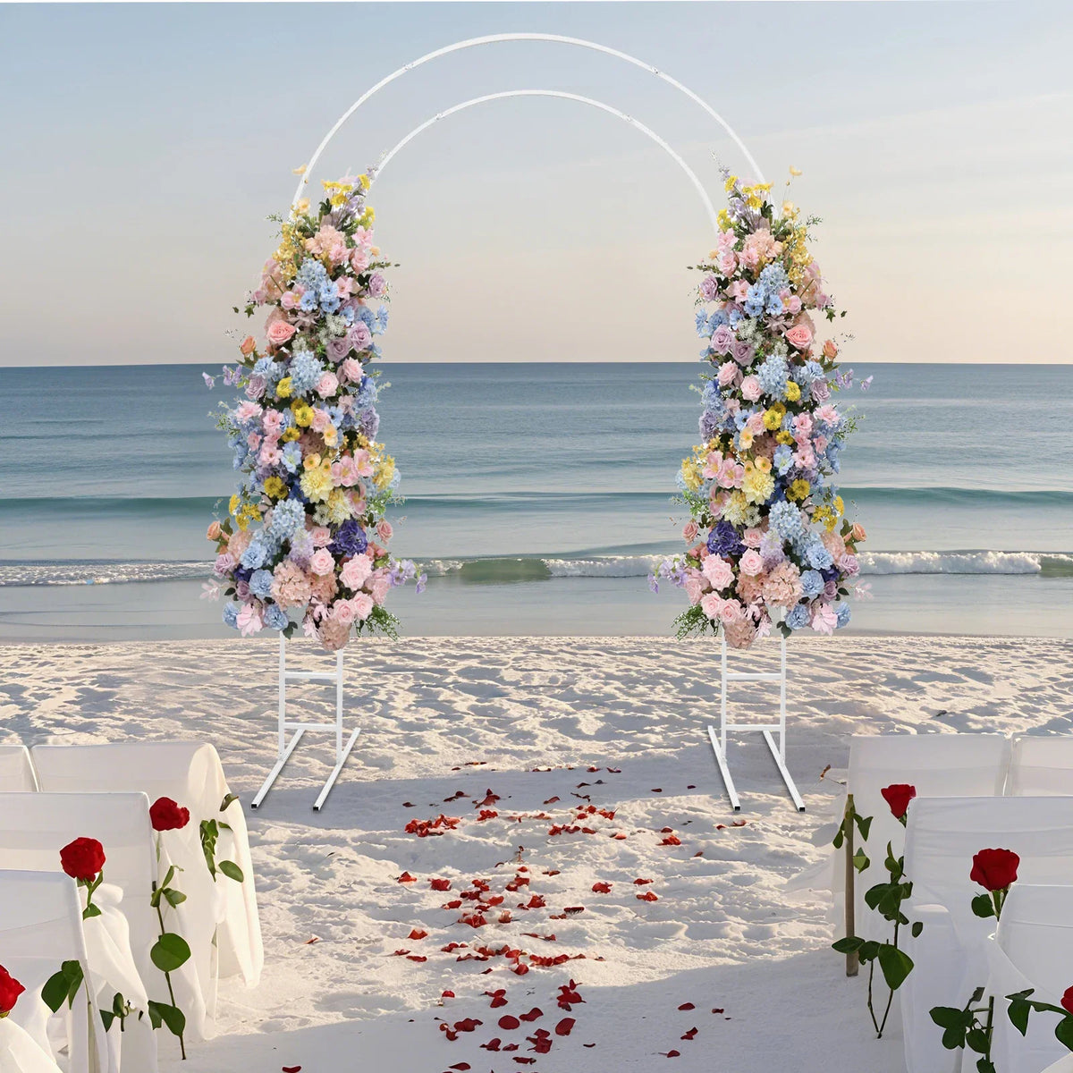 White metal round arch frame decorated with colorful flowers on a beach wedding aisle