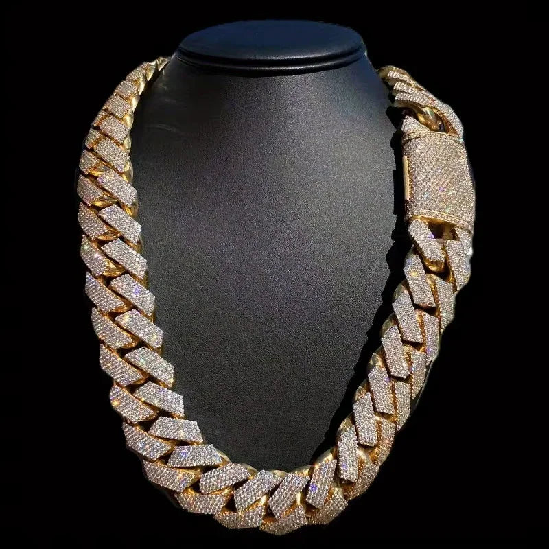 Iced out gold tone Cuban link necklace on a black jewelry display stand