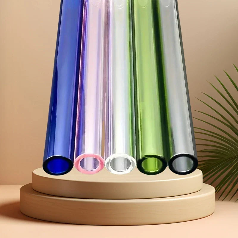 Five colorful glass straws standing vertically on a wooden platform.