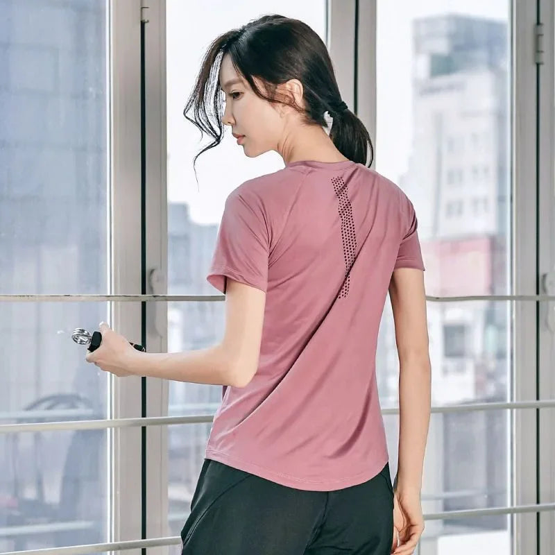 Pink short-sleeve athletic shirt for women back view showing mesh ventilation