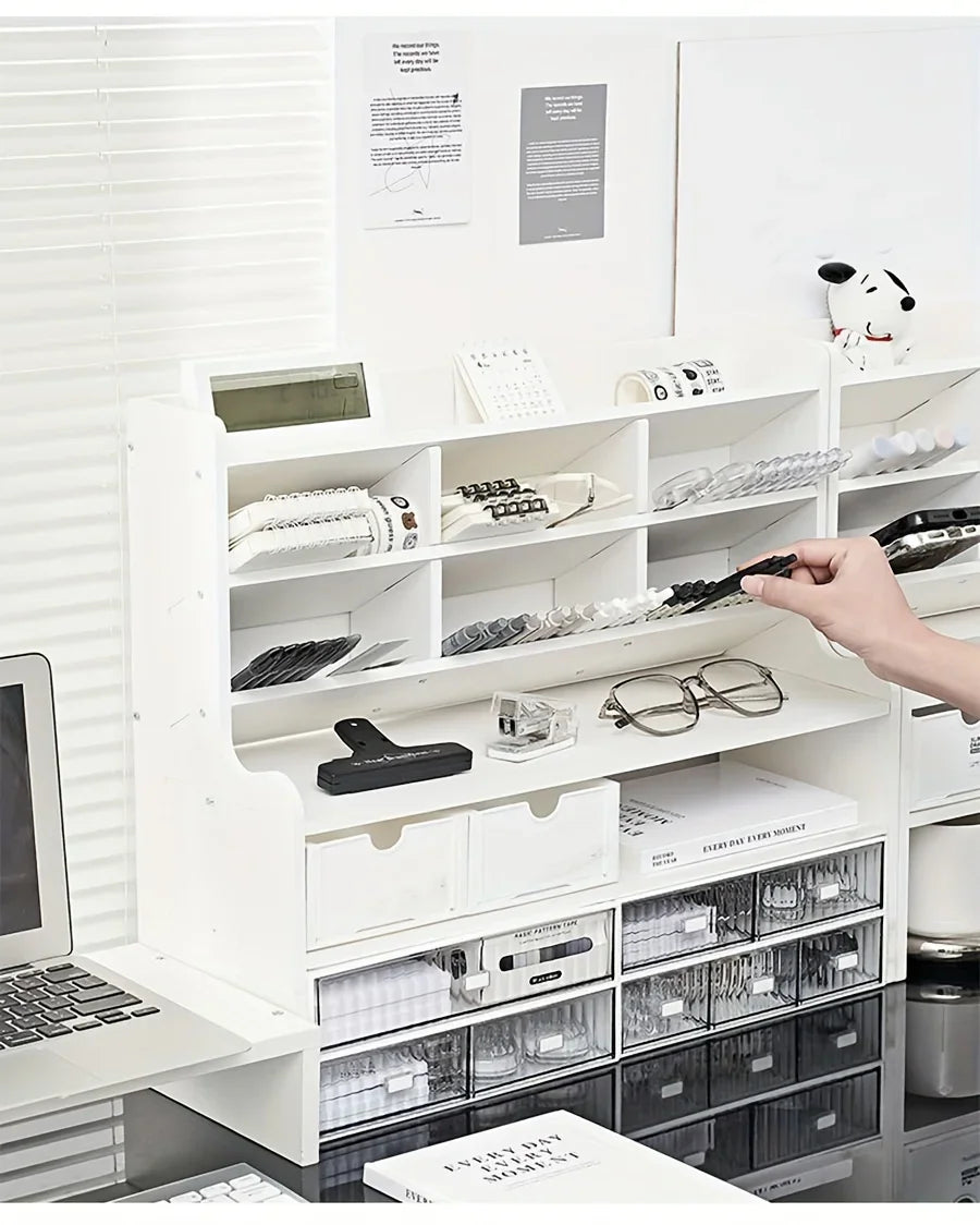 Person organizing stationery in a white desk shelf unit