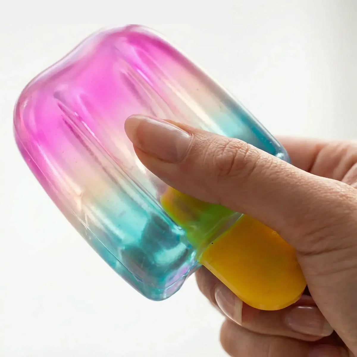Hand holding a transparent gradient popsicle-shaped squishy fidget toy