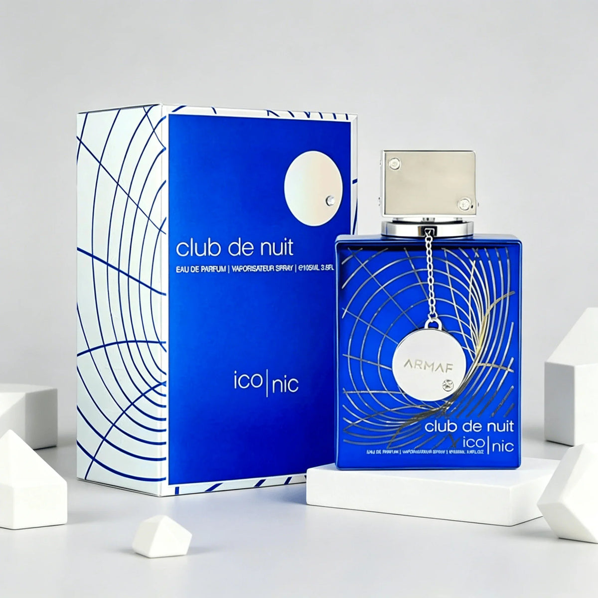 Blue perfume bottle and box displayed with white geometric cube decorations.