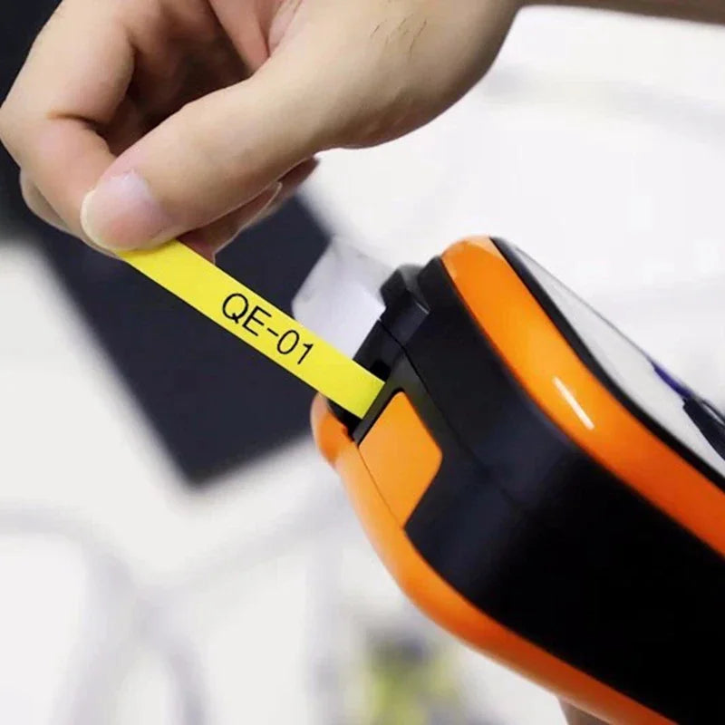 Hand applying yellow heat shrink tube label to a cable using a handheld label maker