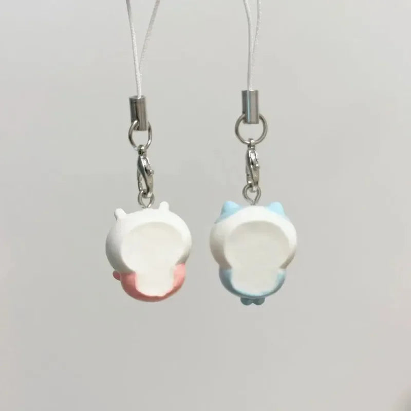 Two back views of character phone charms showing empty backs of the resin figures.
