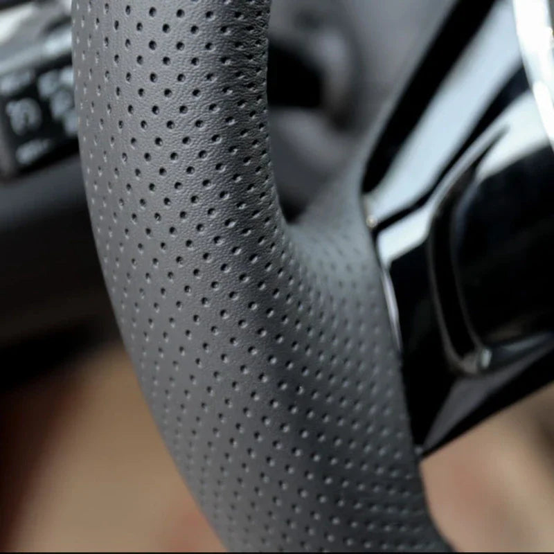 Detail close-up of black perforated leather car steering wheel wrap texture