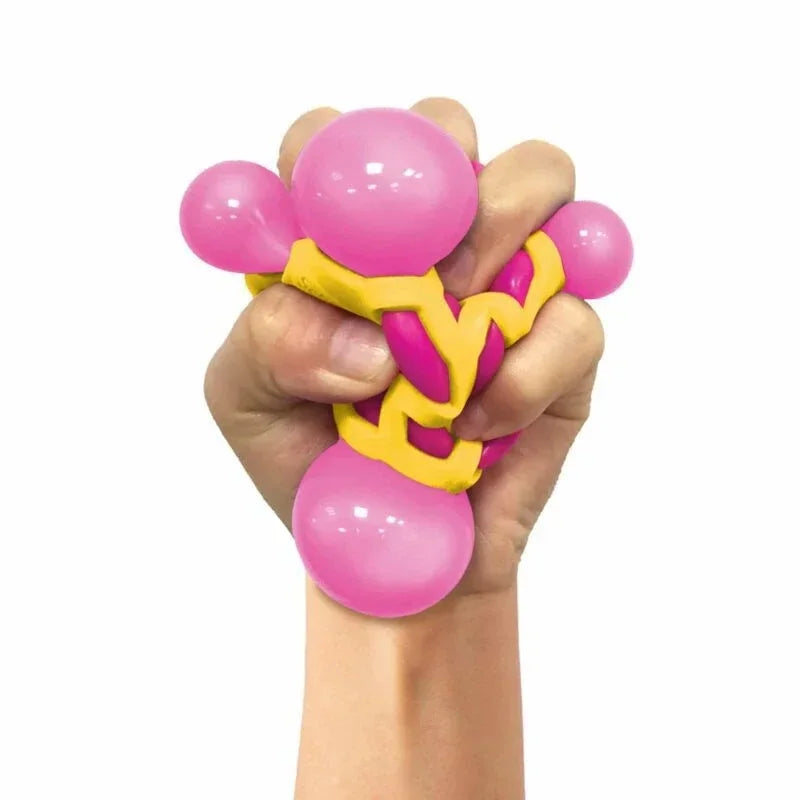 A human hand squeezing a pink and yellow textured stress relief toy