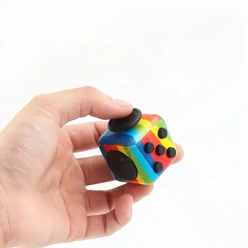 A person holding a rainbow-striped sensory fidget cube with various buttons and controls on a white background.