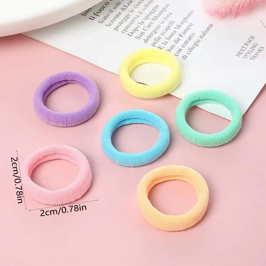 Small seamless fabric hair elastics in five pastel colors with size measurement overlay