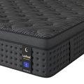 A close-up of a charcoal-grey hybrid mattress with a textured quilted top and dark side panels.
