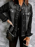 Woman wearing a dark grey distressed denim jacket over a black shirt, posing with a black shoulder bag