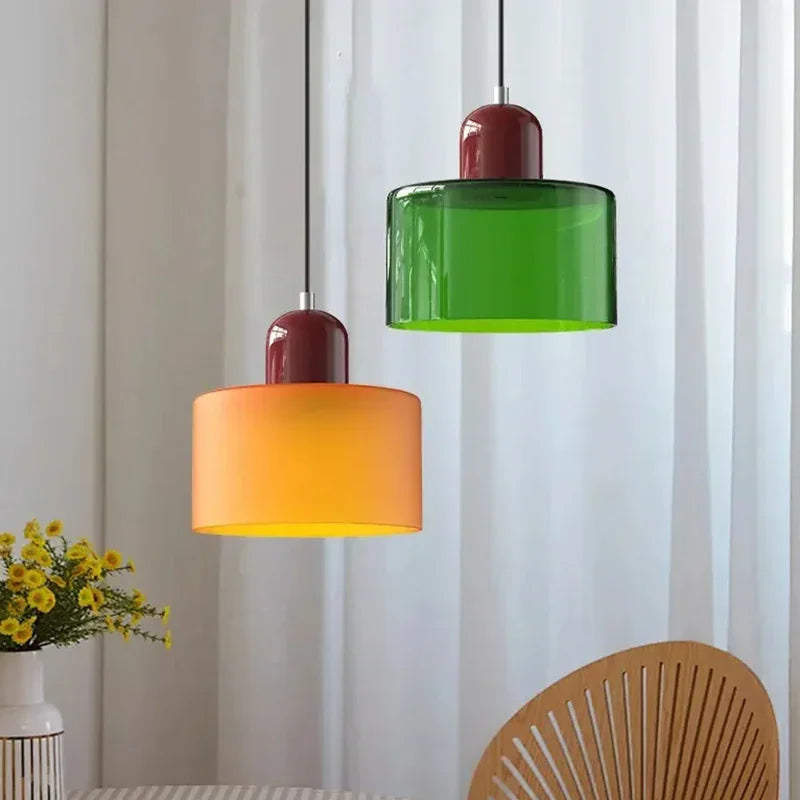 Two modern glass pendant lights hanging in a dining room