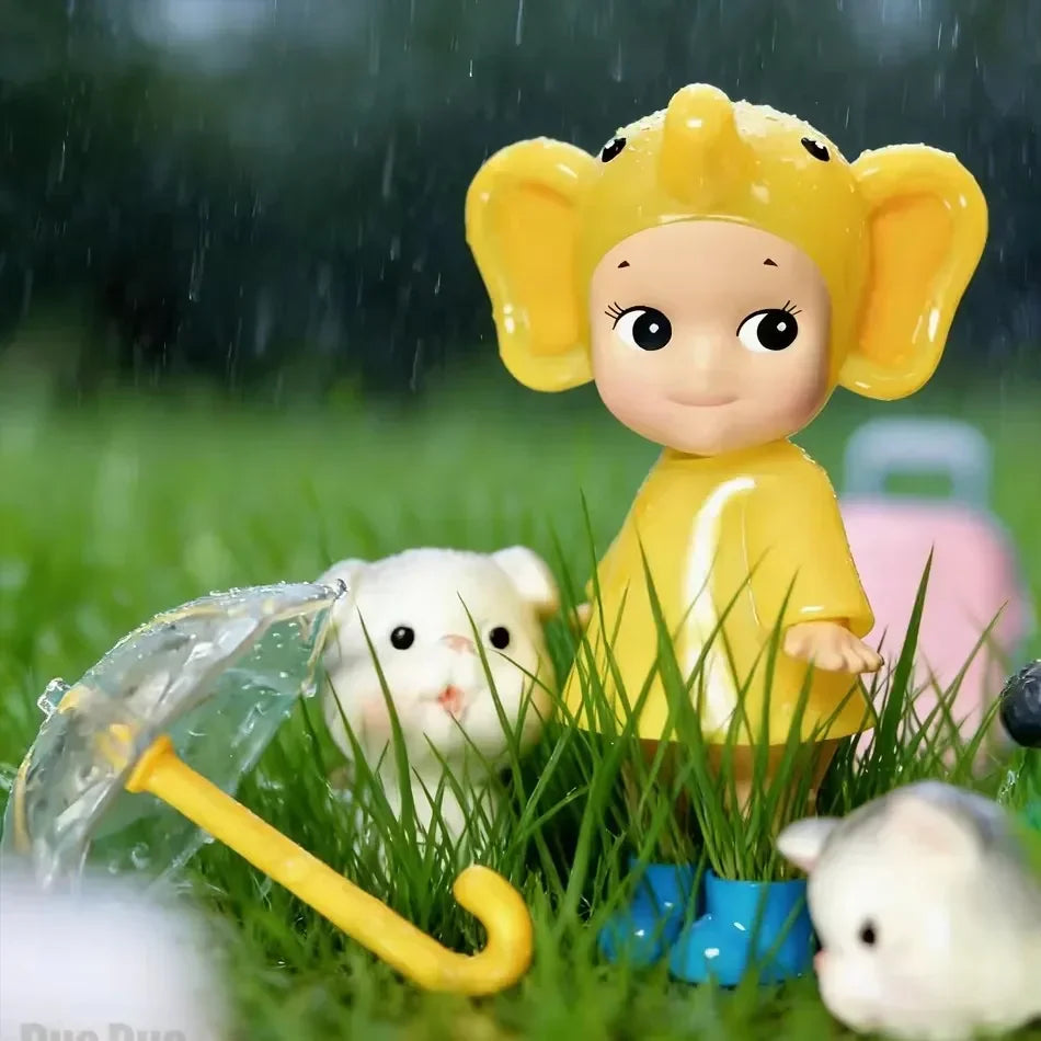 Small collectible doll figurine in a yellow elephant hat and raincoat in the rain with a toy puppy