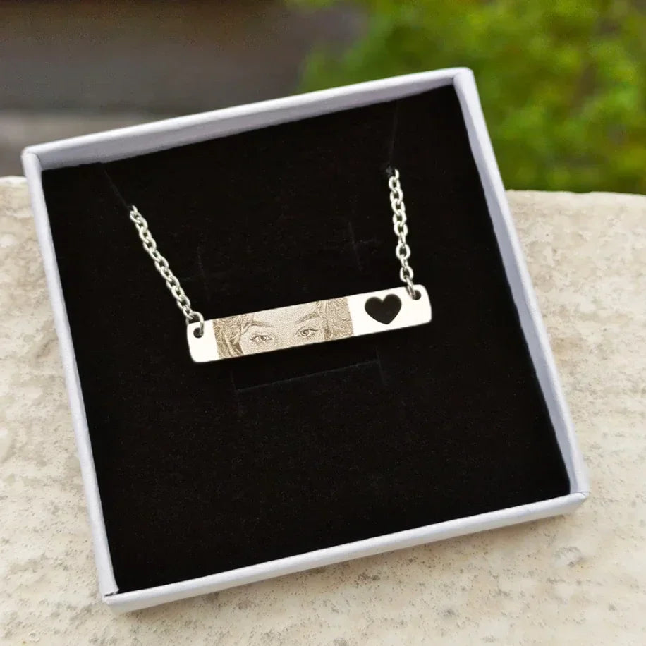 A single silver bar necklace with a photo engraving and heart cutout, presented in a gift box.