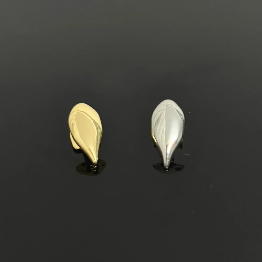 Close up of gold and silver single vampire tooth grillz