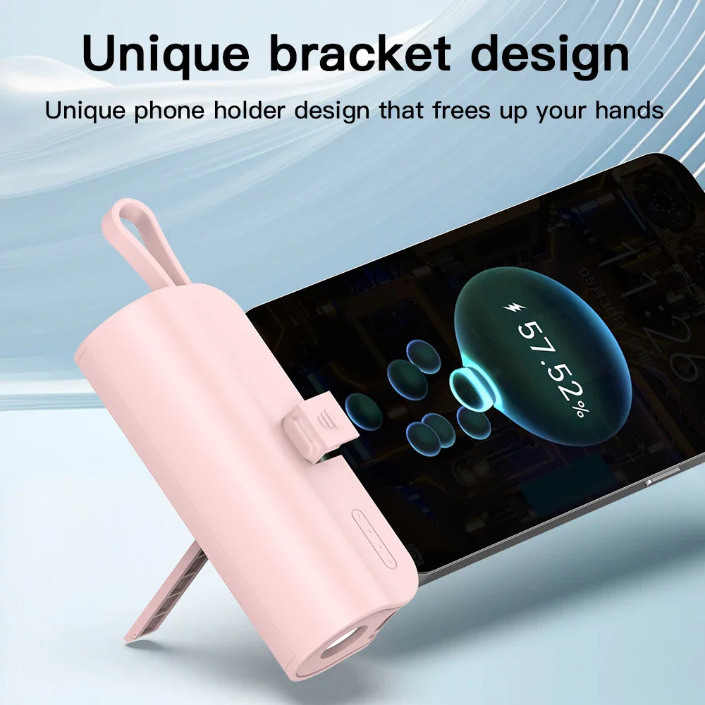 Pink mini portable power bank featuring a built-in stand function supporting a mobile phone.
