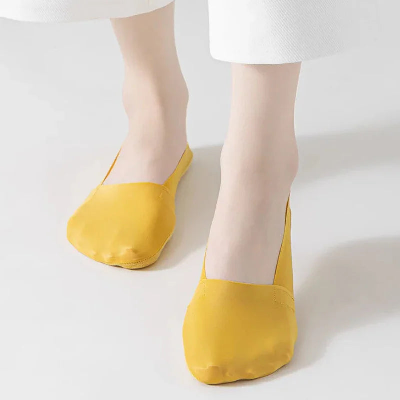 Yellow invisible low-cut liner socks on a pair of feet