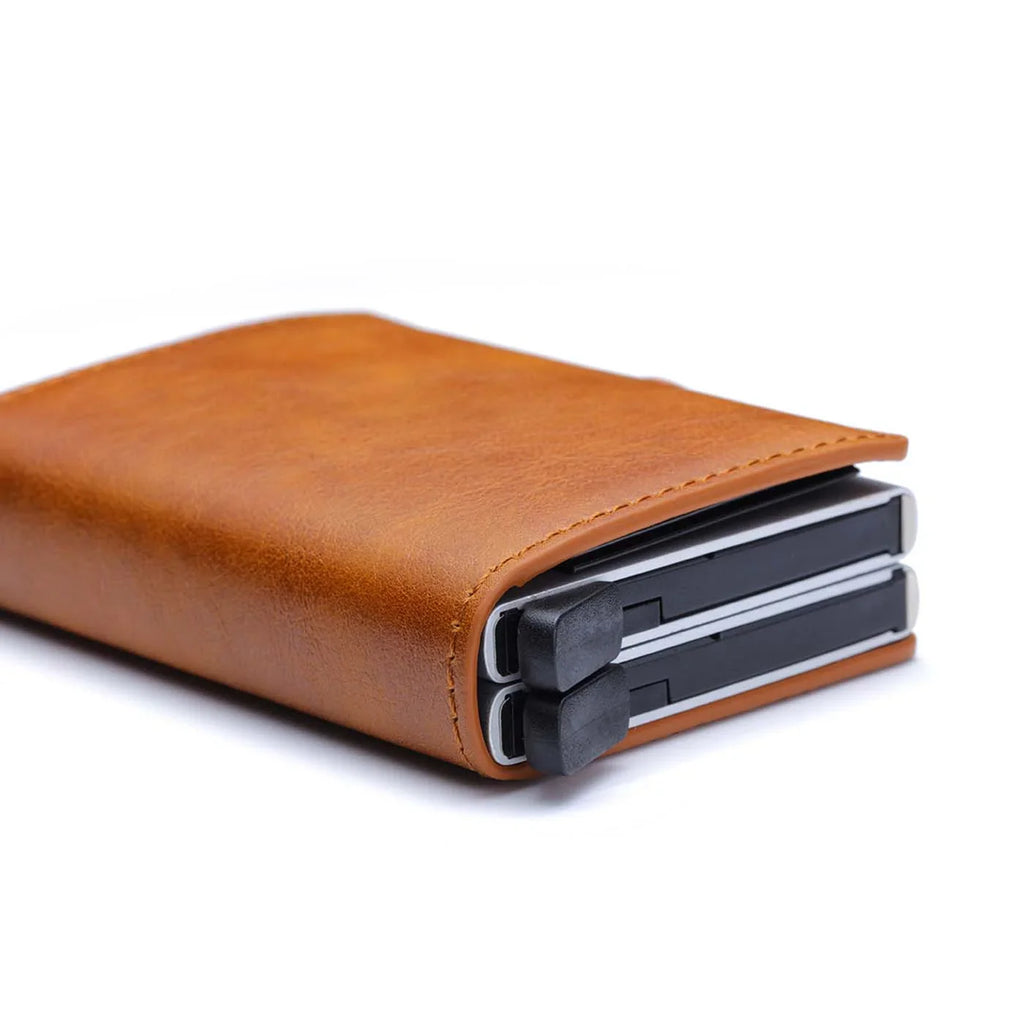 Side view of the brown leather slim wallet showing the mechanism triggers.