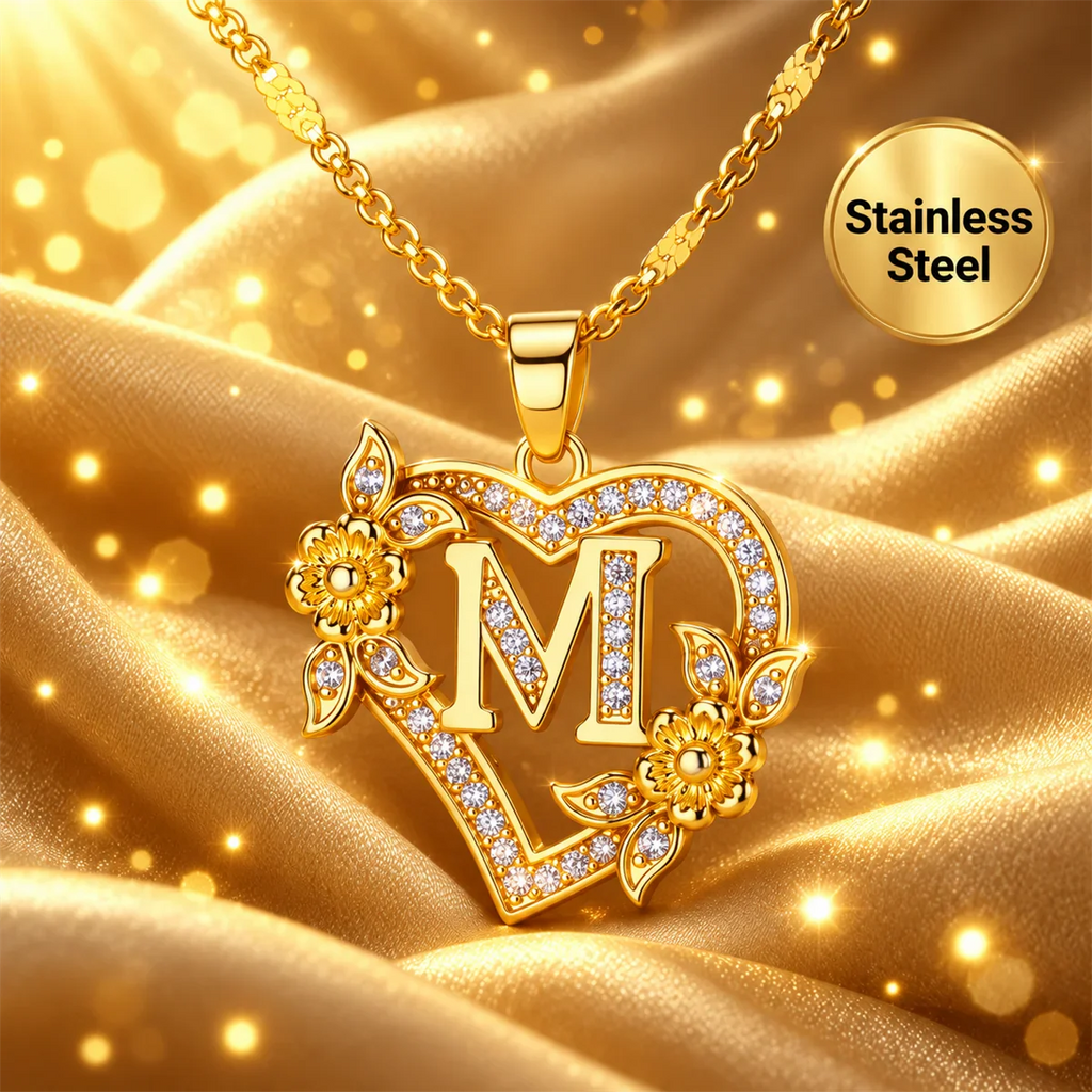 Single gold heart-shaped initial necklace with floral details on gold satin fabric
