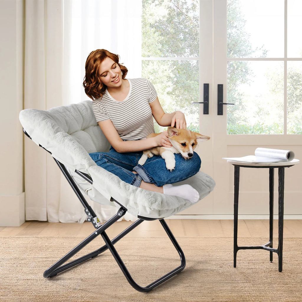 Woman sitting on a white faux fur saucer chair with a puppy