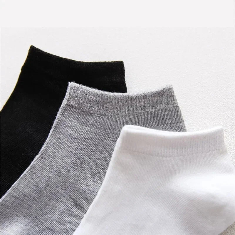Close-up view of black, grey, and white low-cut ankle socks stacked together.