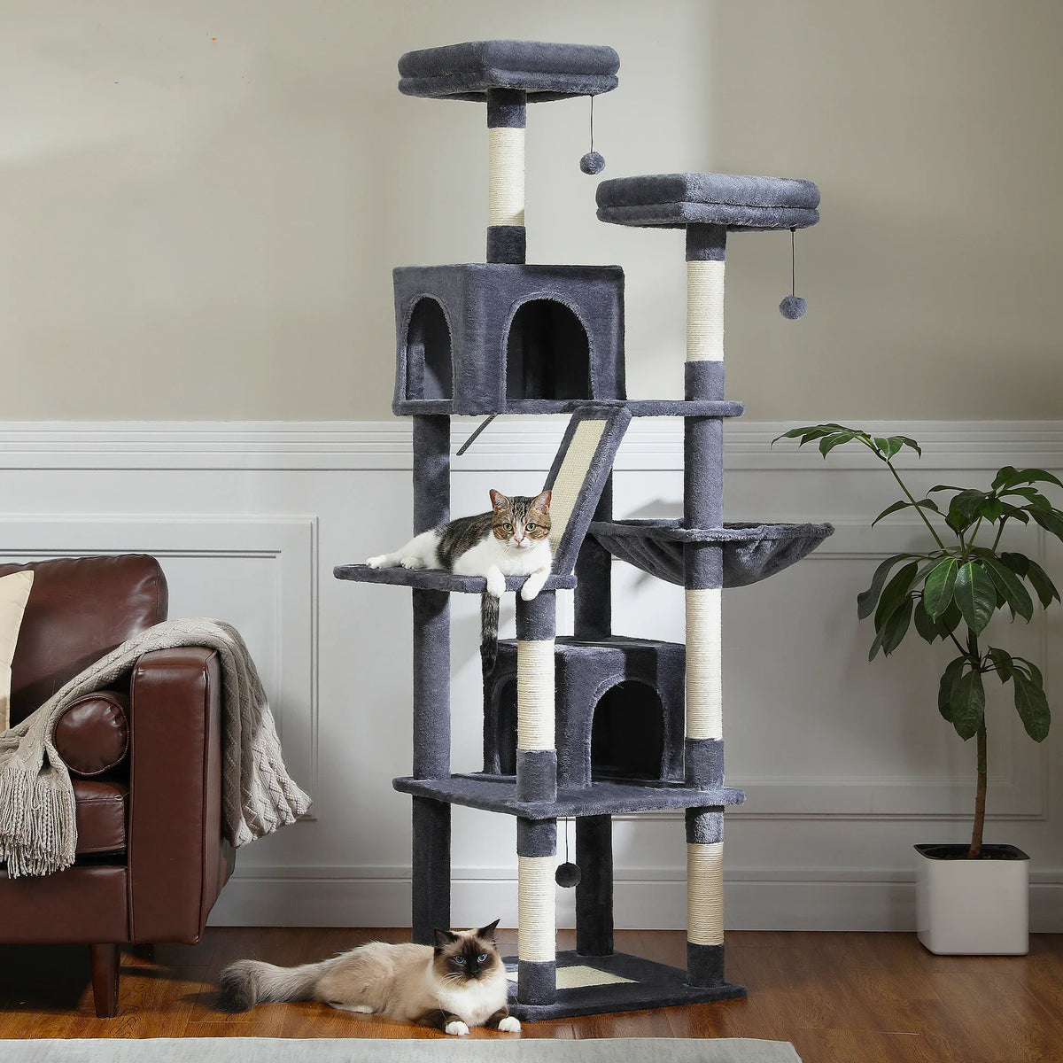 Large multi-level dark grey plush cat tree tower with scratching posts, perches, and condos with two cats.