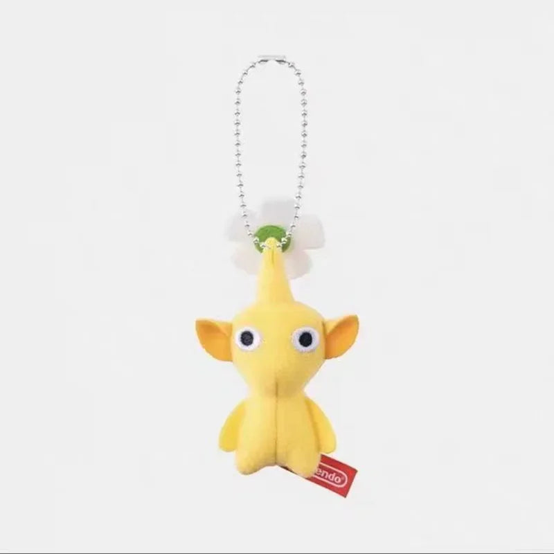 A small yellow plush doll keychain with large ears and a white flower on its head