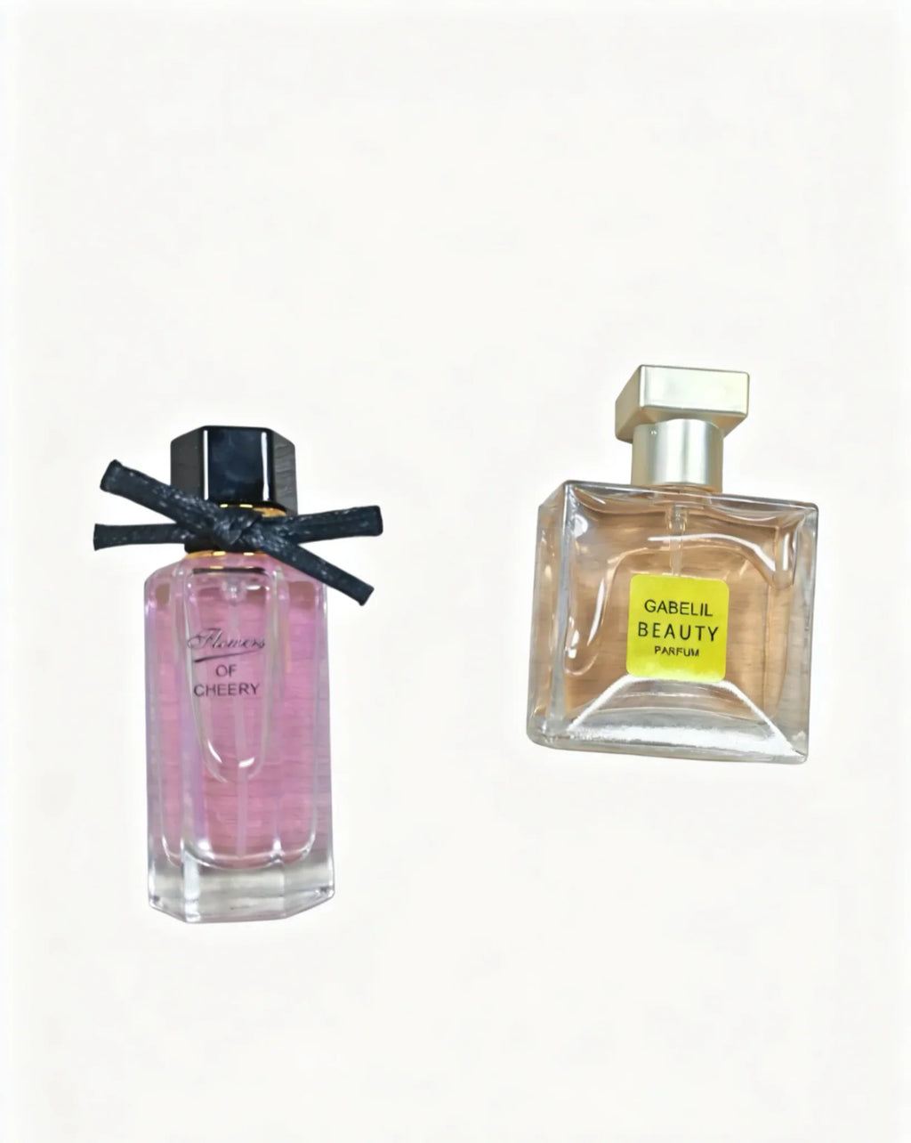 Two perfume bottles, a tall pink bottle with a black bow and a square bottle with a yellow label.