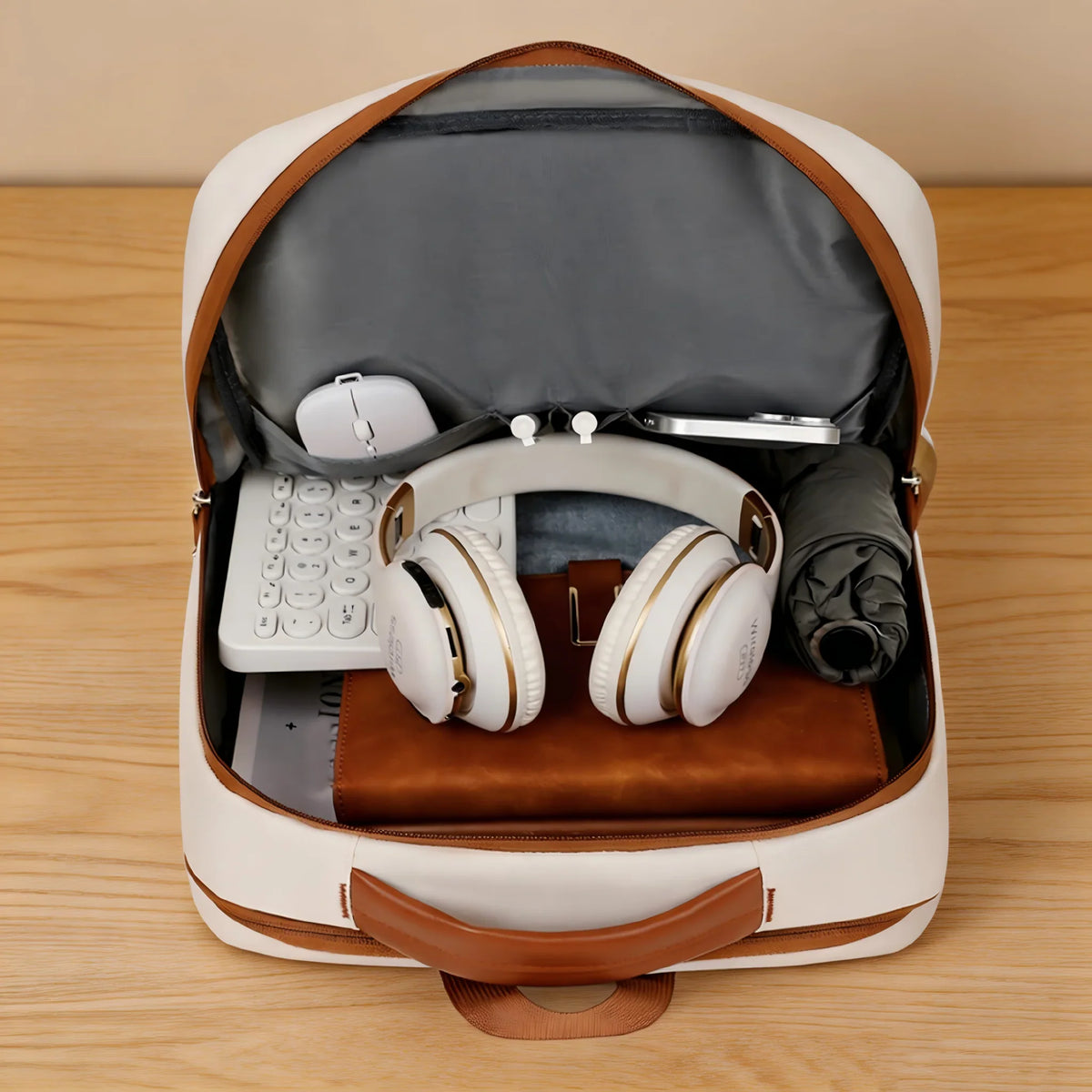 The interior of a beige laptop backpack showing organized storage pockets for a mouse, headphones, and notebook.