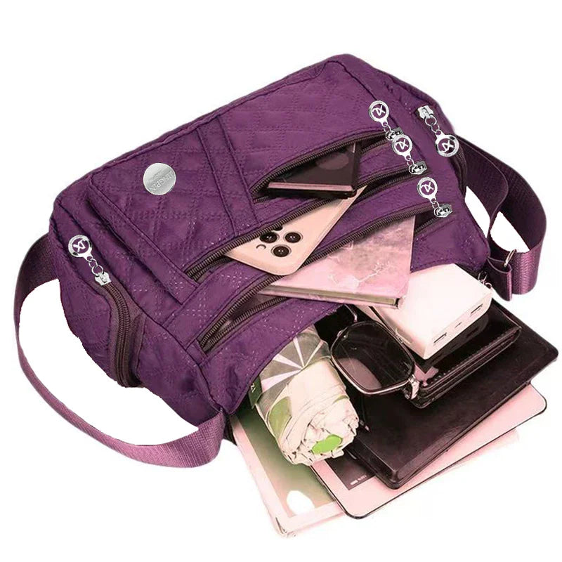 Purple quilted nylon crossbody bag filled with personal items