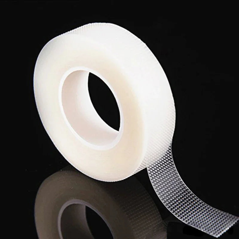 Single roll of transparent micropore tape for eyelash extensions on black background