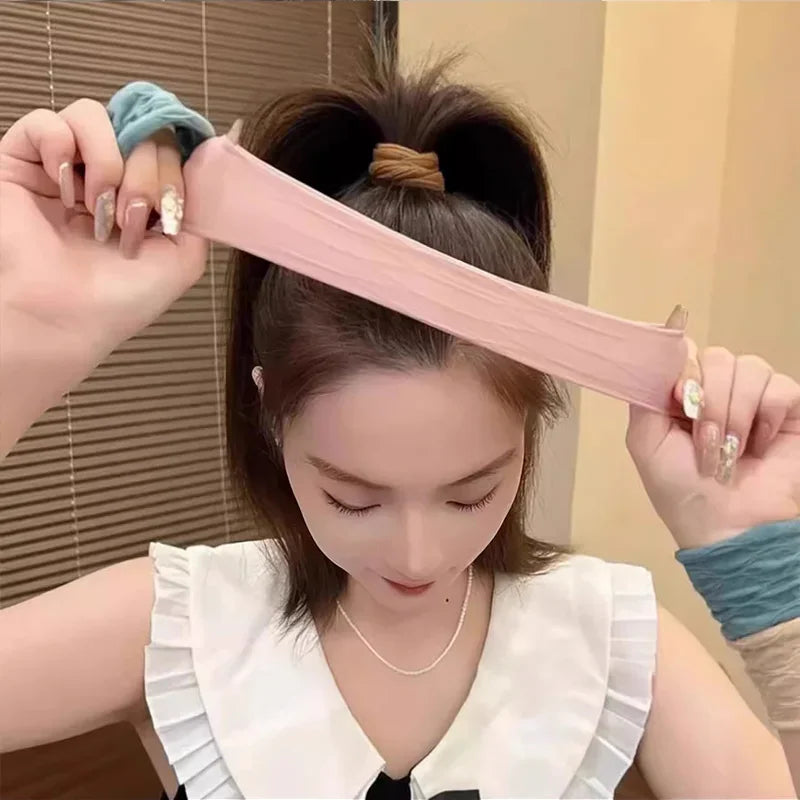 A woman demonstrating the high elasticity of a pink hair scrunchie by stretching it with her hands