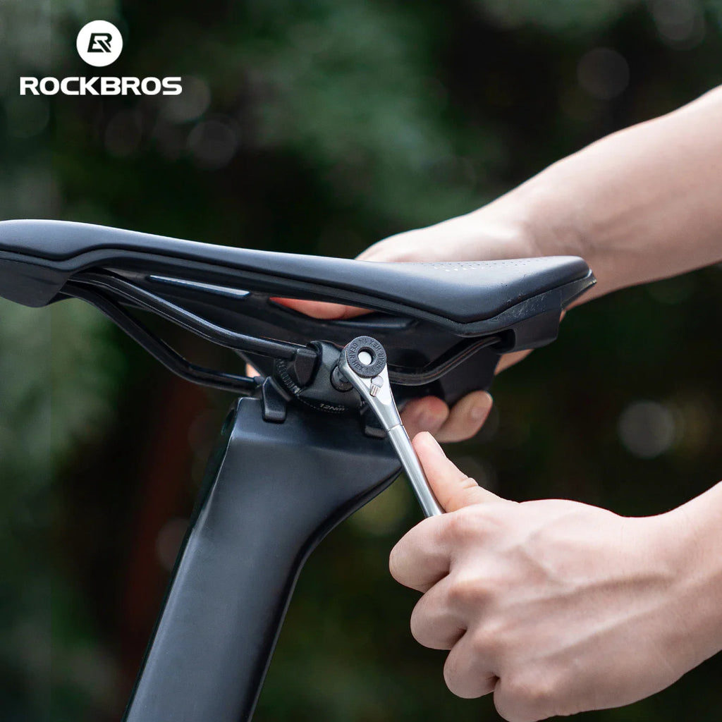 Person using a ratchet wrench to adjust a bicycle seat post clamp