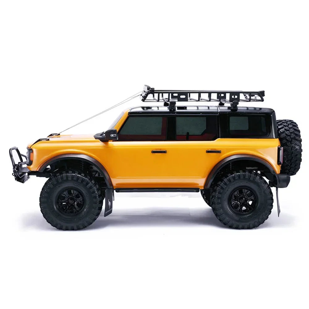 Orange remote control off-road truck with limb riser cables installed on a white background