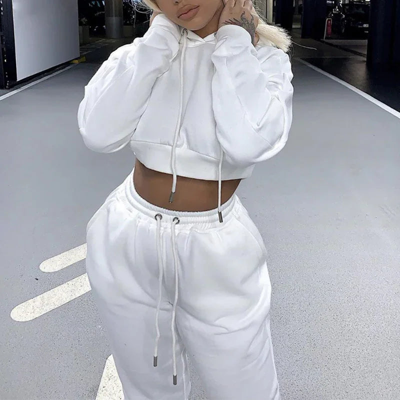 A woman wearing a white cropped hoodie and matching white sweatpants jogger set