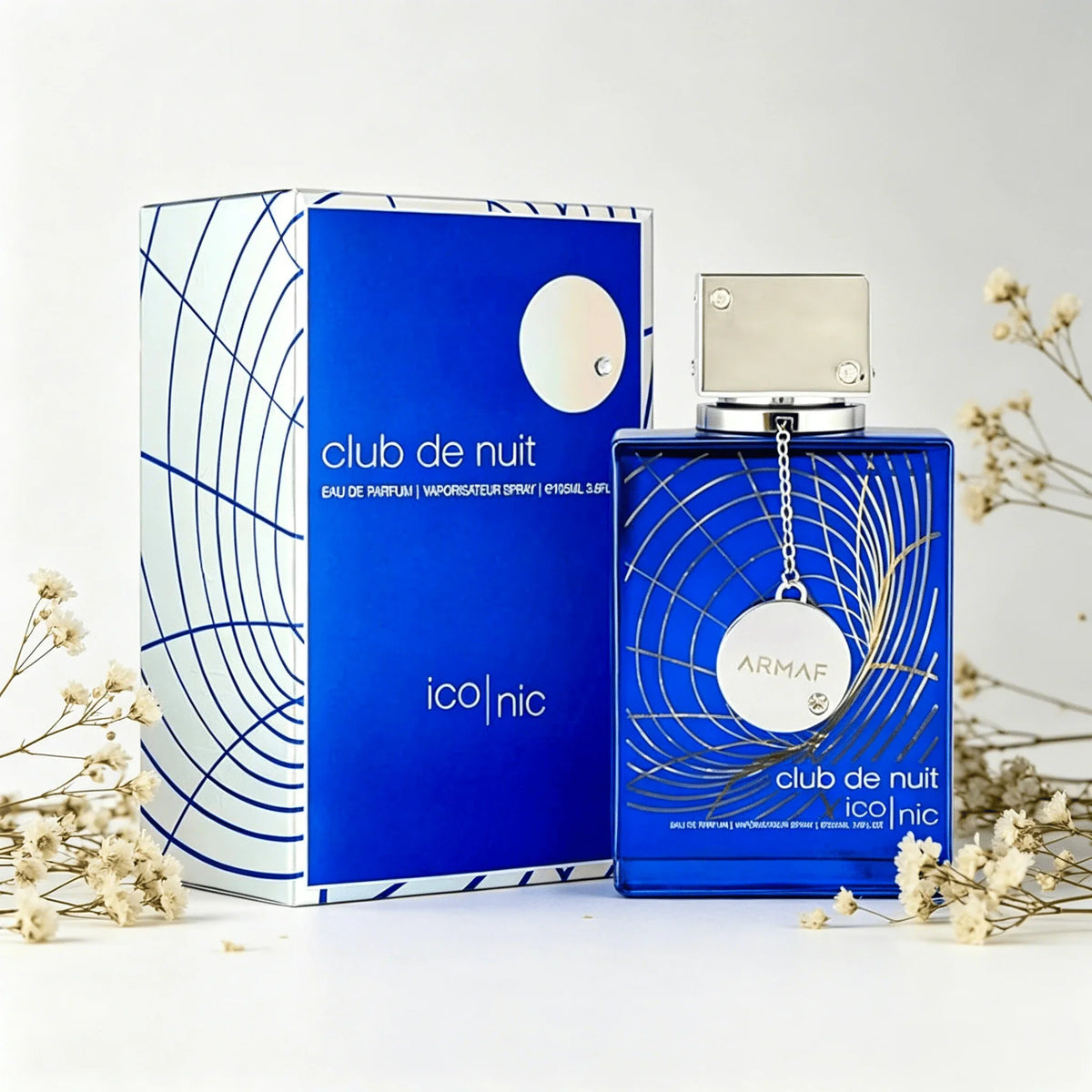 Blue perfume bottle and box styled with small sprigs of dried white flowers.