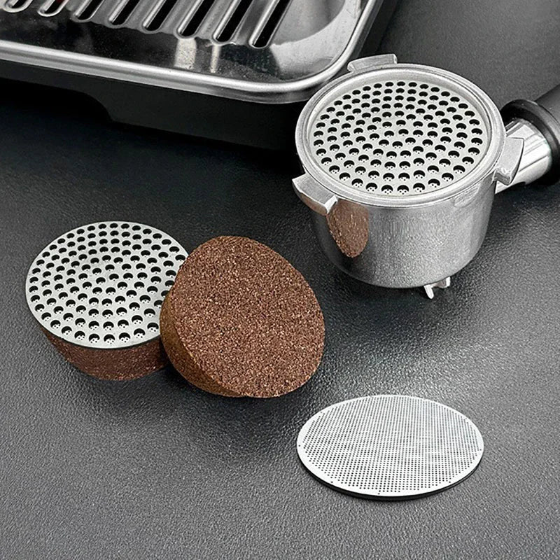 Espresso portafilter with a puck screen, used coffee pucks, and a clean mesh filter screen