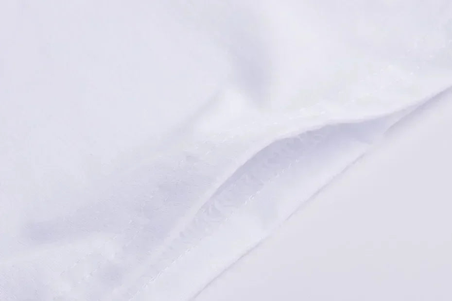 Extreme close-up of the hem stitching on a white t-shirt fabric