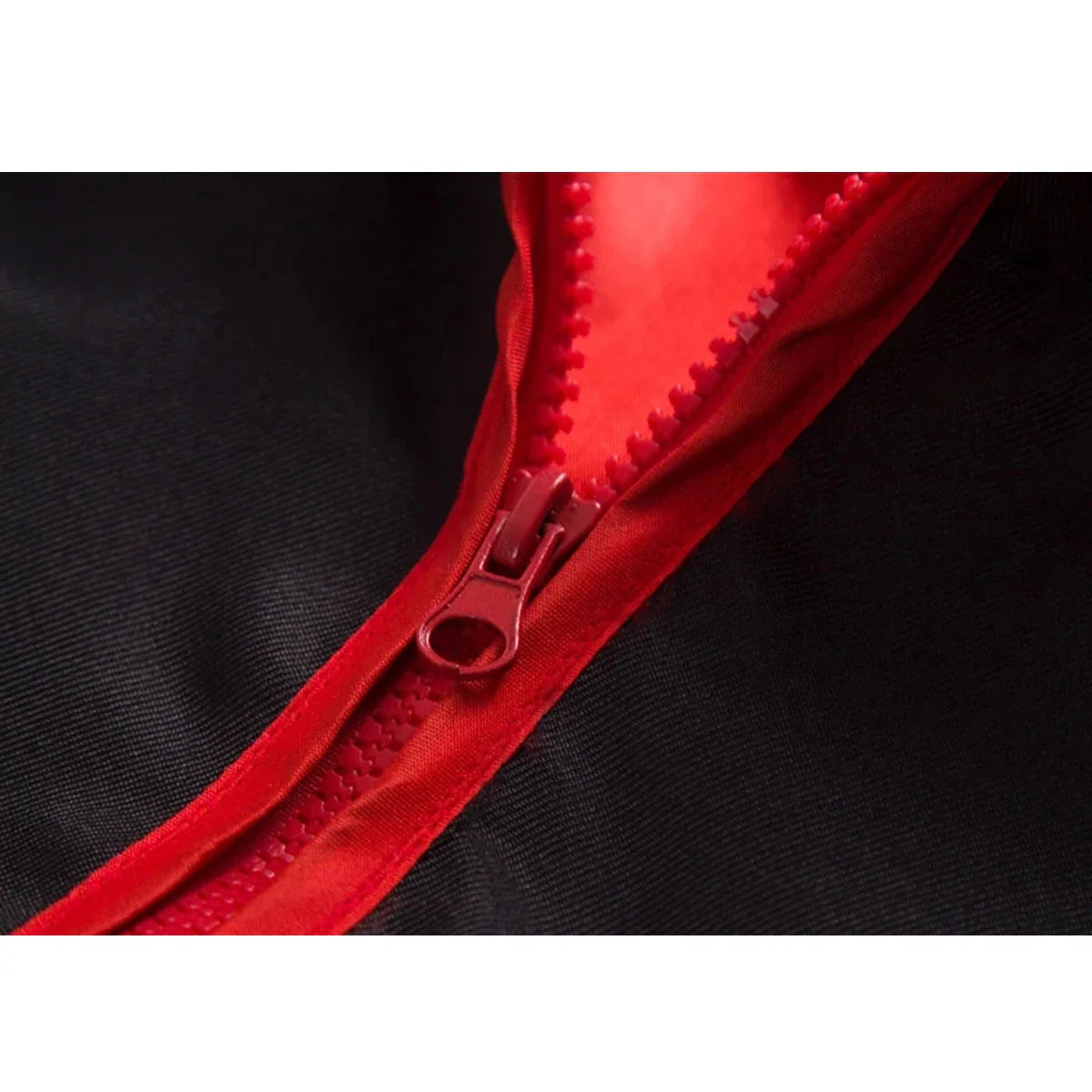 Close-up of a red zipper on a black cosplay cloak