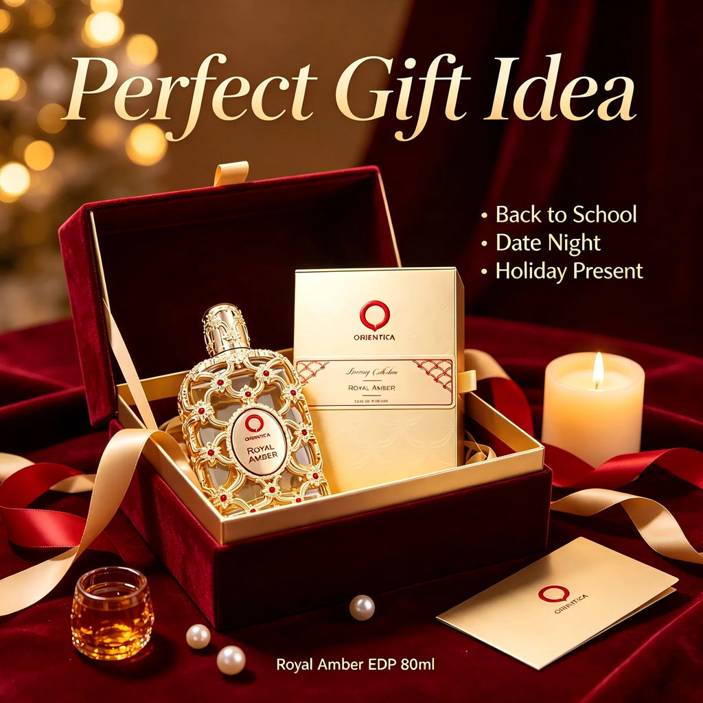 A luxury gold perfume bottle and box in a velvet lined gift box with ribbons and a candle.