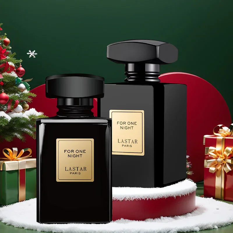 Two black perfume bottles displayed with Christmas decorations, gifts, and snow.