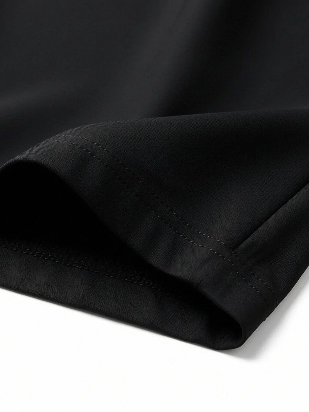Close-up of hem and stitching detail on black athletic shorts