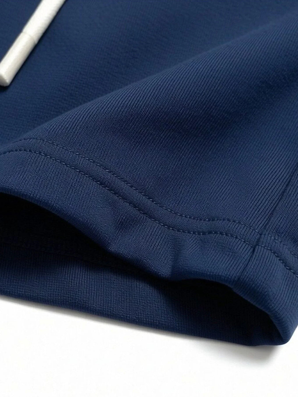 Close-up of the hem stitching on navy blue shorts.
