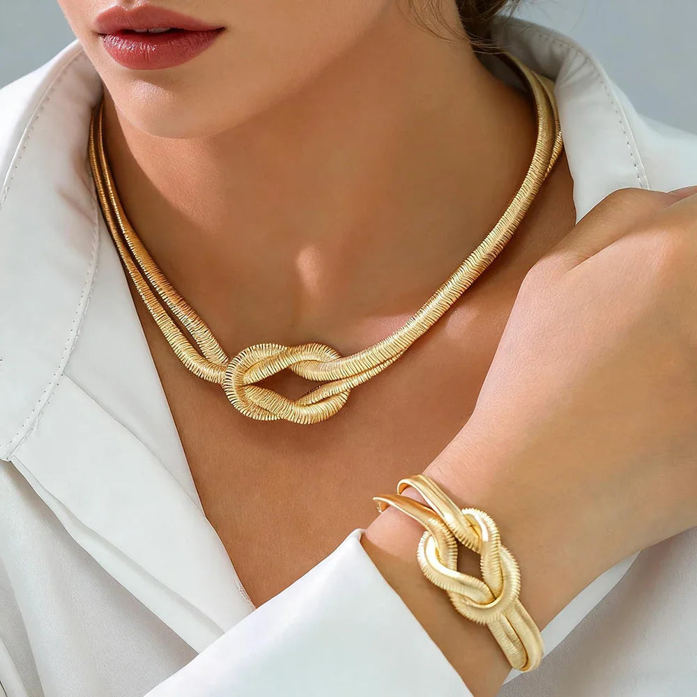 Gold double layer knot necklace and bracelet jewelry set worn by a woman