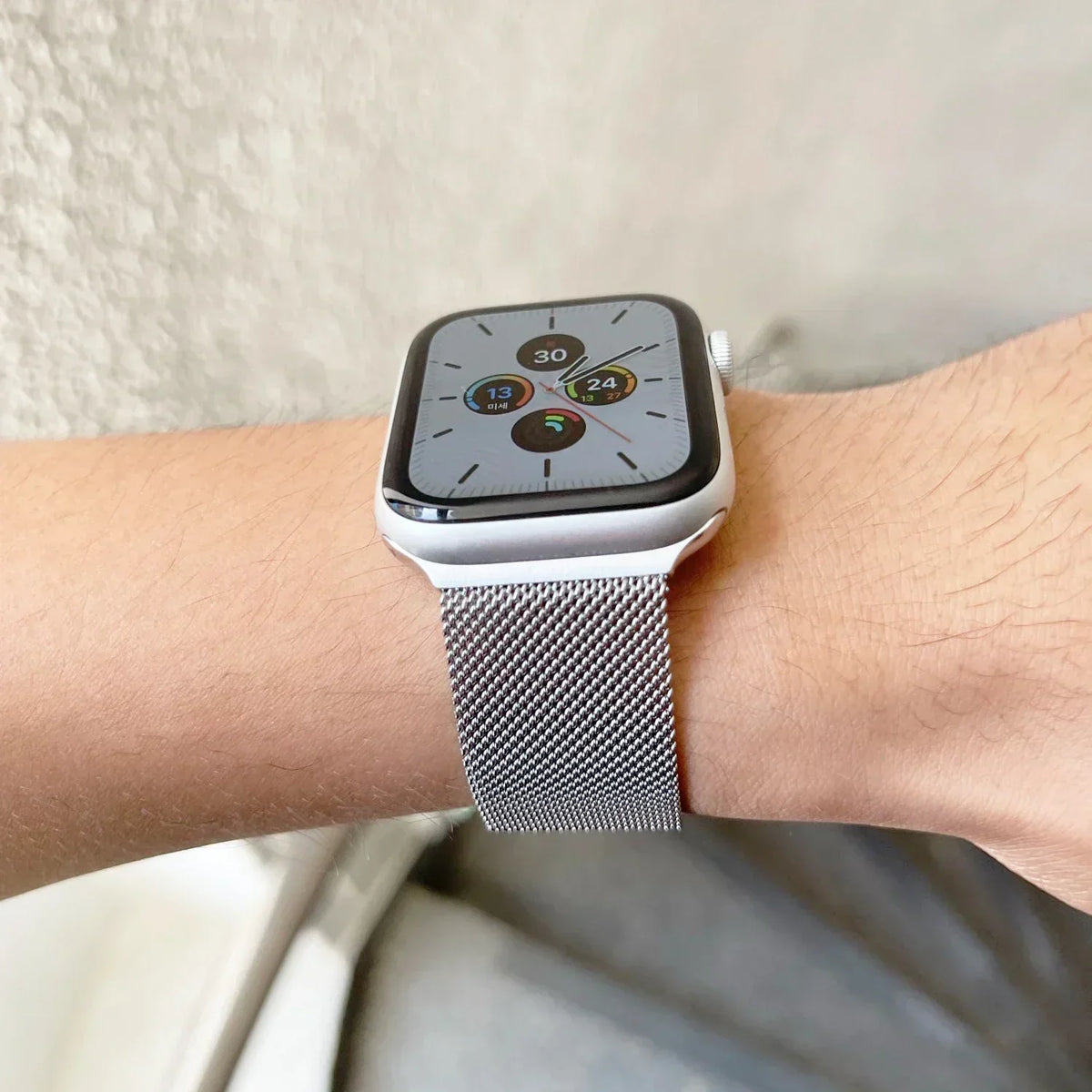 Silver metal mesh watch band worn on a person's wrist