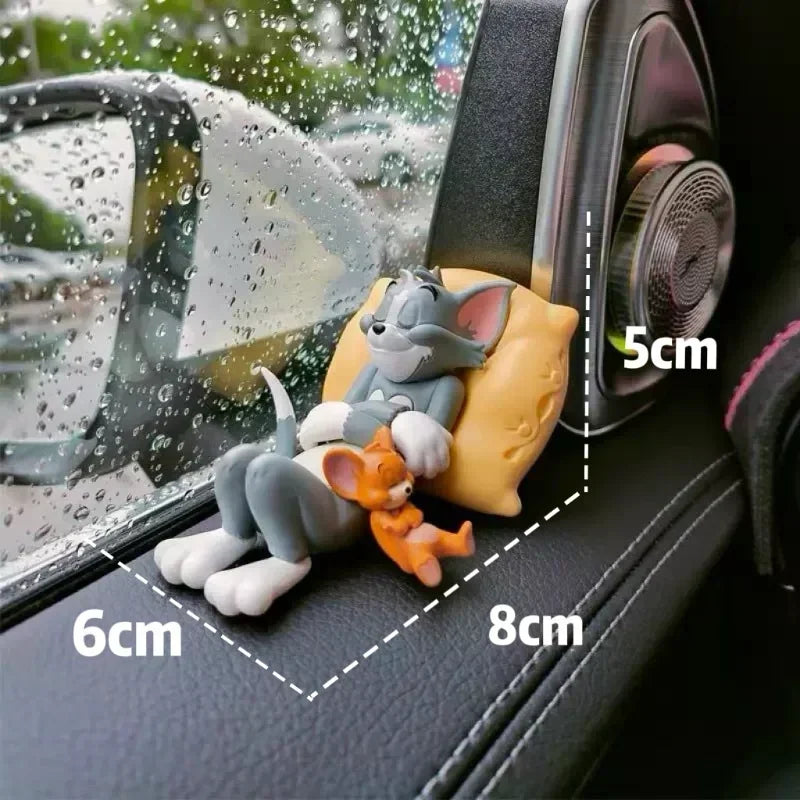 Small cat figurine sleeping on a yellow pillow on a car dashboard with dimension labels