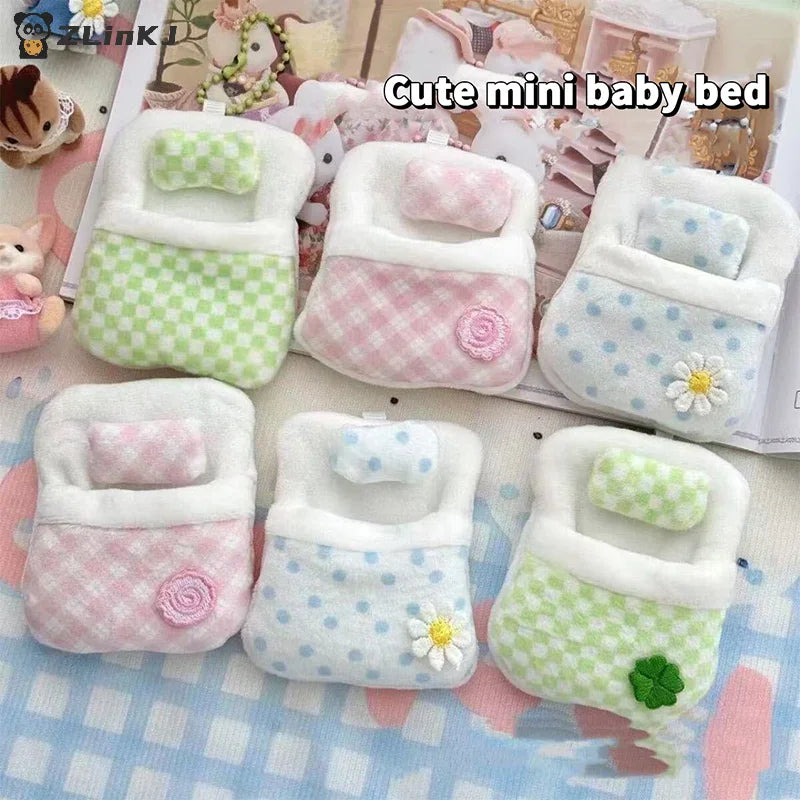 Selection of miniature plush doll beds with floral and gingham patterns